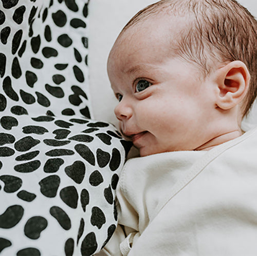 Baby laying on Dalmatian print muslin from Etta Loves.