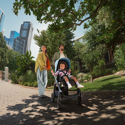 Mom and dad with child pushing the Bugaboo Dragonfly Stroller in -- Color_Skyline Blue