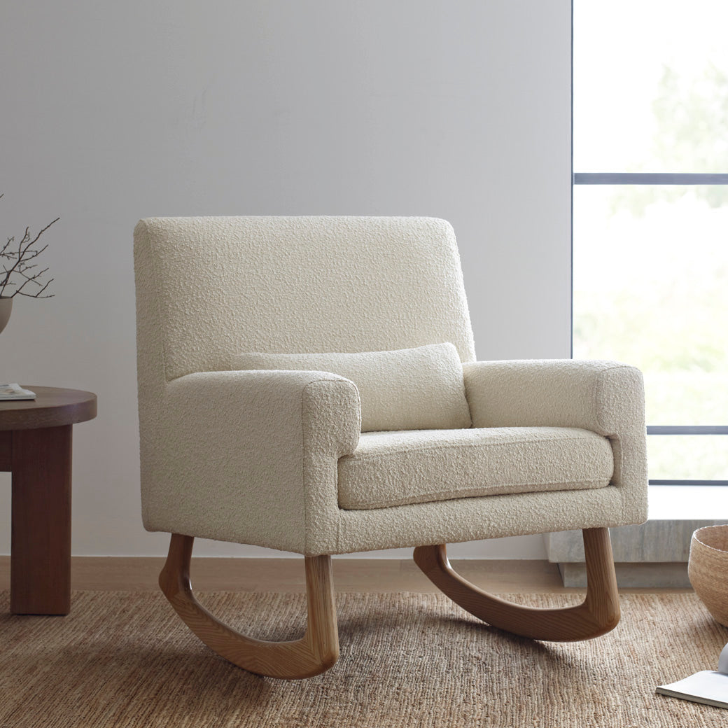 Nursery Works Sleepytime Rocker in a room next to a table in -- Color_Ivory Boucle with Light Legs