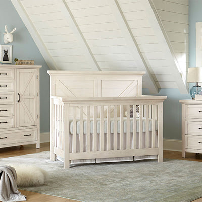 Westwood Design Westfield Convertible Crib in a room next to a dresser  in -- Color_Brushed White