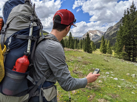 Backpacker using emergency communication device