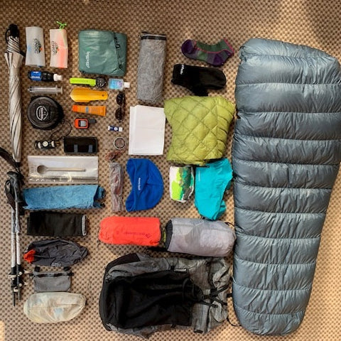 Backpacking gear laid out on the ground