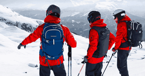 Three skiers with safety gear