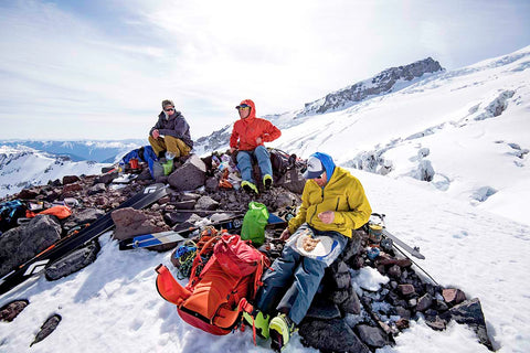 Group of backpackers summiting a mountain in the winter