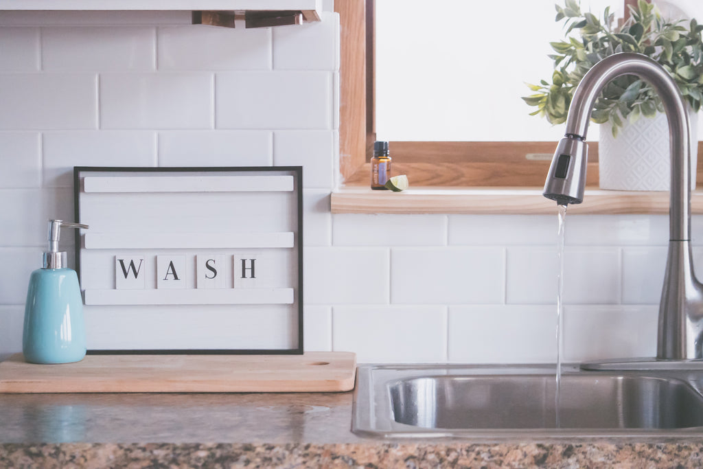 faucet-with-water-and-soap-in-bathroom-with-wash-inscription