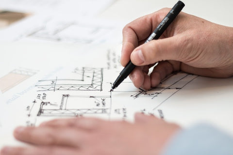 Person holding black pen in the home building process