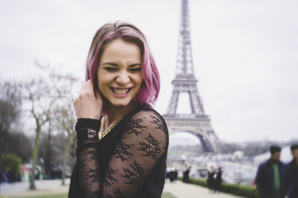 Young woman with pink hair in front of Eiffel Tower Paris