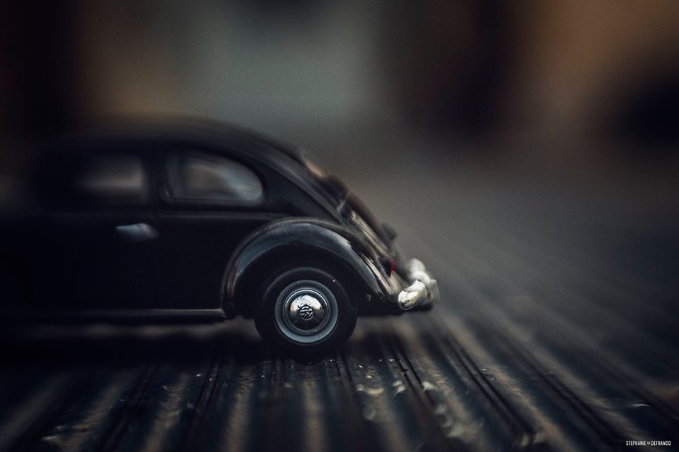 VW bug black and white toy car on striped street selective focus muse Lensbaby featured photos