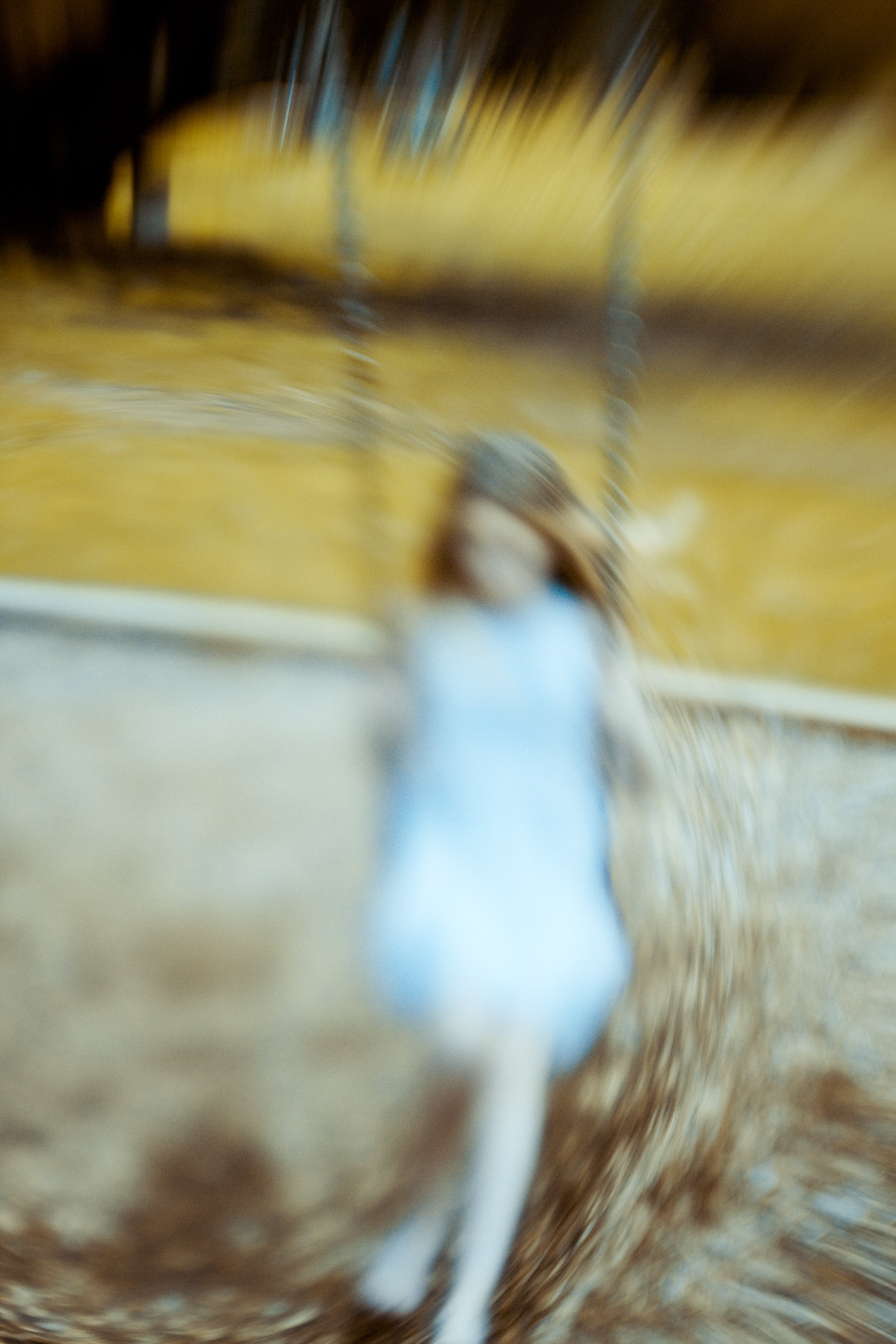 woman in white dress with blond hair on swing blur lensbaby journey story marianne ellis