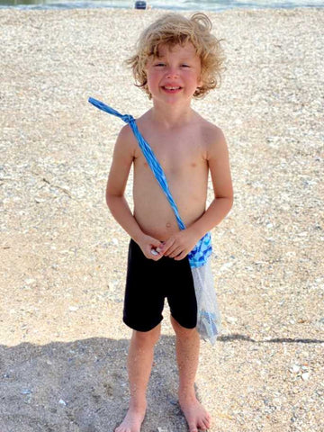 Boy standing on a sandy North Carolina beach.