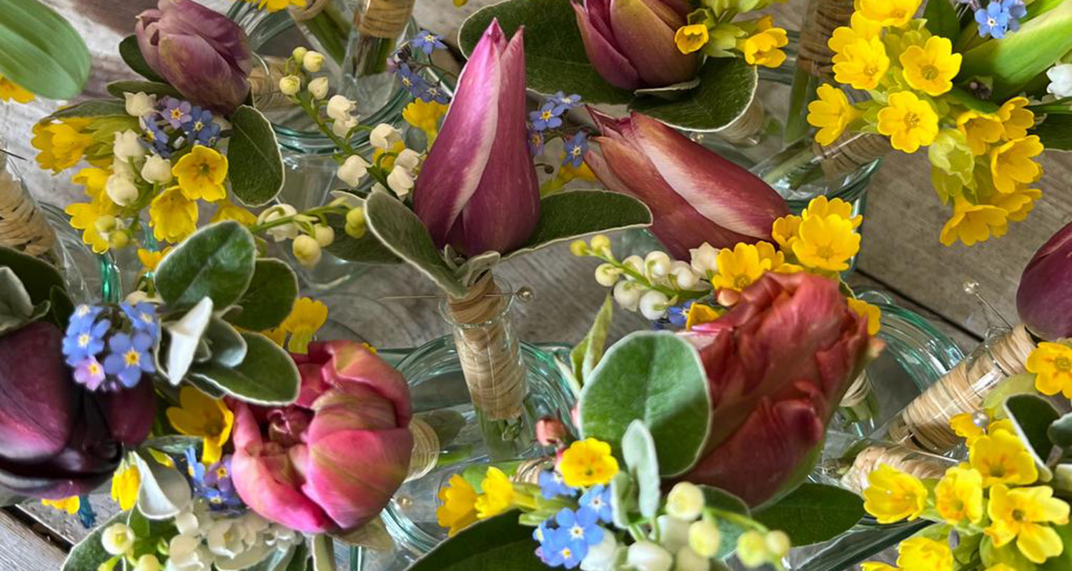 Image shows a collection of buttonholes created with Spring flowers - bluebells, tulips, cowslips and forget me nots.