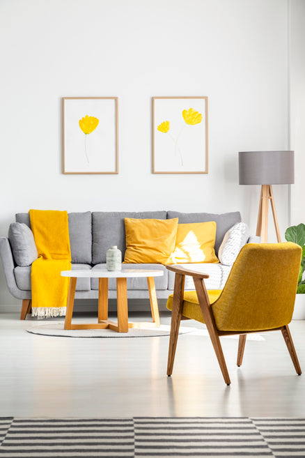 posters-with-yellow-flowers-hanging-gray-couch-bright-living-room-interior-with-retro-armchair-wooden-coffee-table-real-photo.jpg__PID:73193c74-2e84-40d4-875d-55c8649cb1fa