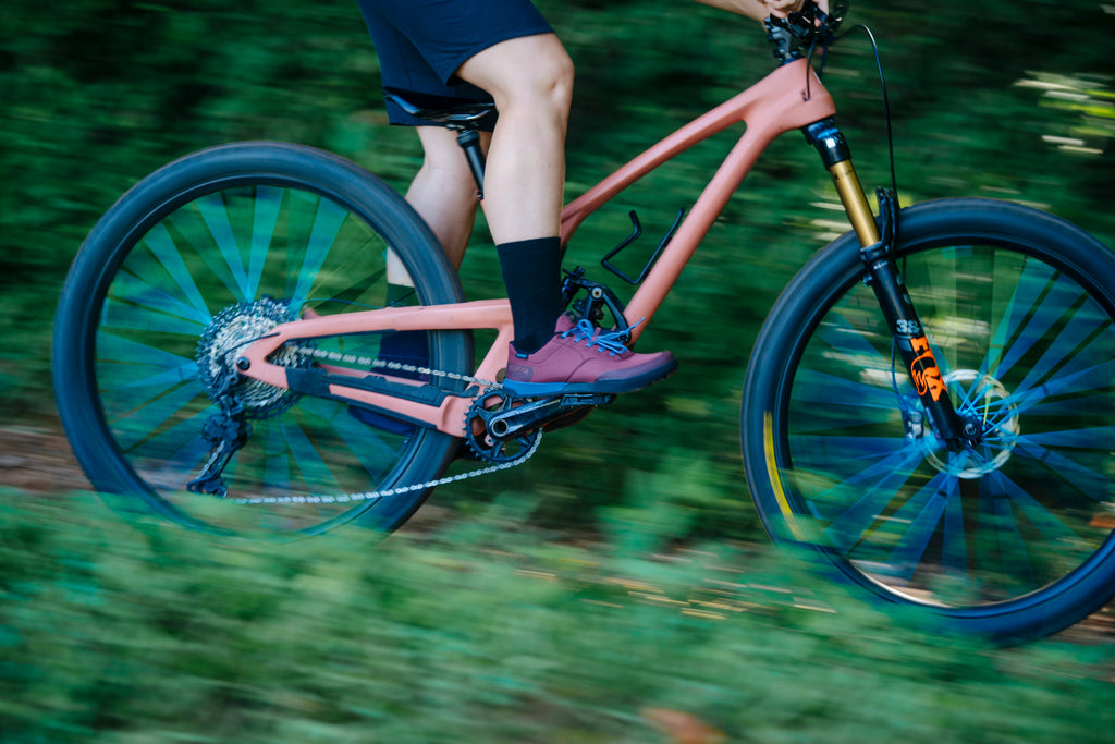 female mountain biker riding down the trail in her Shimano SH-GF400 MTB flat shoes