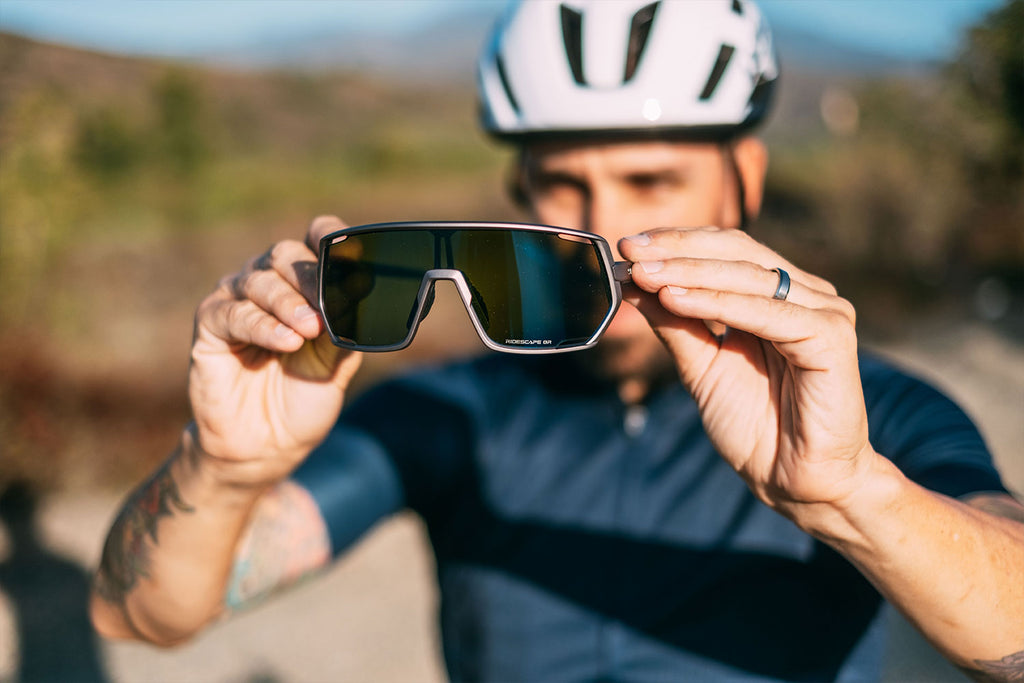 Man holding a pair of Shimano Gravel ridescape sunglasses
