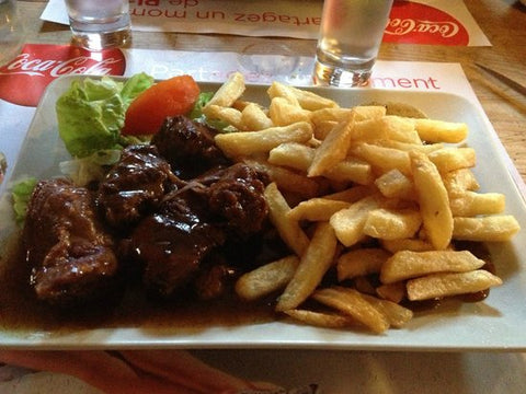 Restaurantteller mit flämischen Carbonade-Pommes und Salat