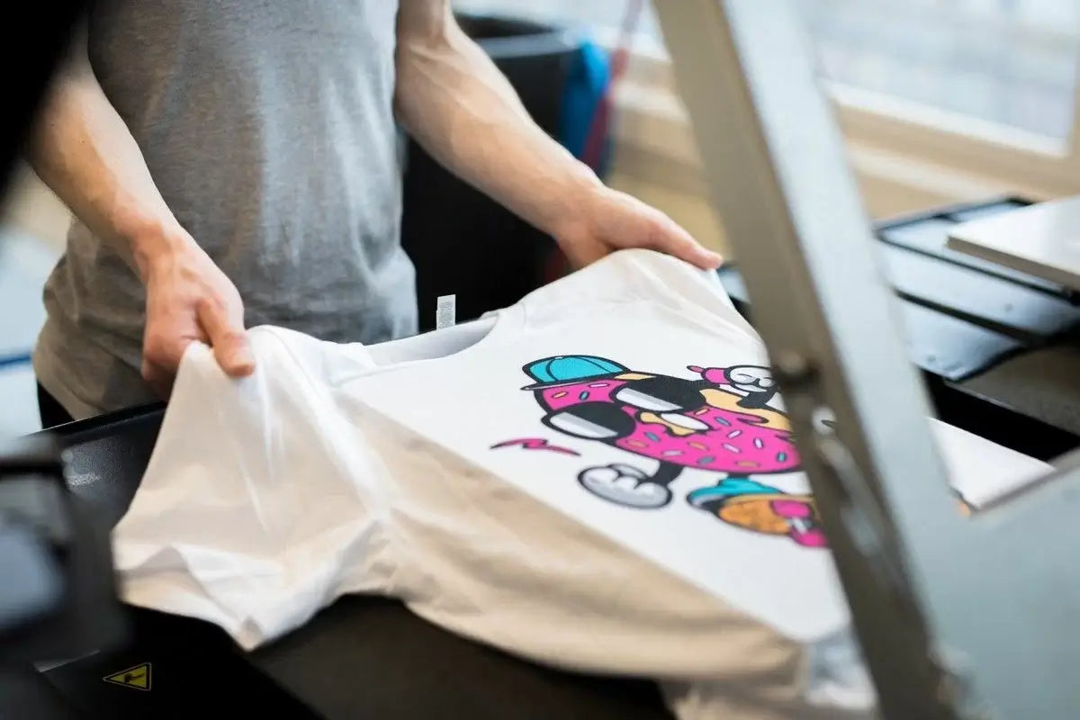 boy is doing DTF printing on a white shirt