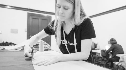 TELAstory founder stitching at a table