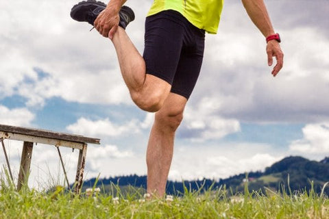 Man doing a standing quad stretch