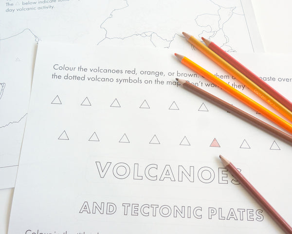 Page of a worksheet on volcanoes showing triangular cut and paste symbols with a handful of coloured pencils