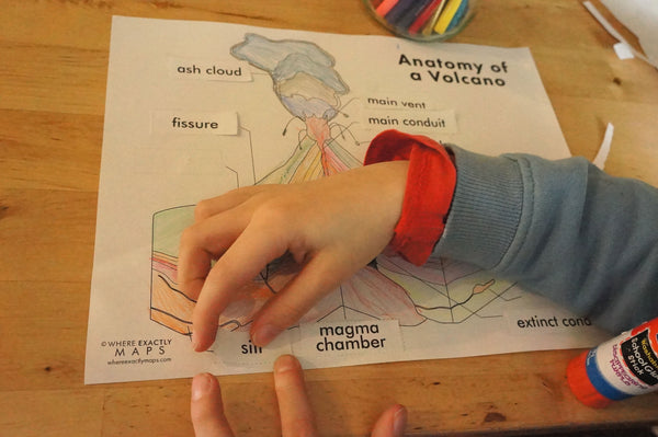 a boy placing labels on a volcano diagram worksheet