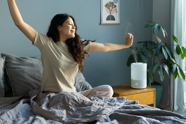 Woman waking up next to Levoit humidifier