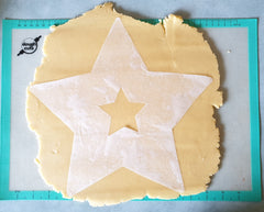 Star template made from parchment paper on cookie dough