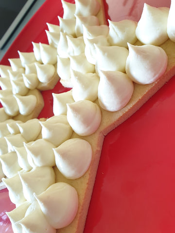 White Chocolate Cheesecake Filling Piped Onto Star Cookie Cake