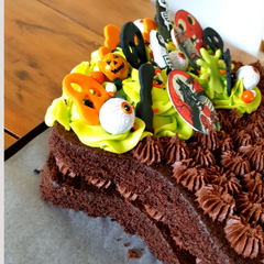 Image of chocolate cake cut into cauldon shape and decorated for Halloween