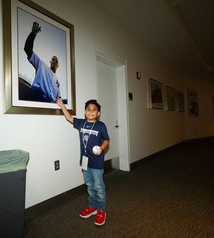 Oliver poses next to a picture of Yankees player Aaron Judge