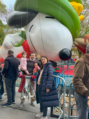 A family with Snoopy blown up behind them