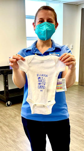 Family Room Manager holds up NICU baby gift at Ronald McDonald Family Room