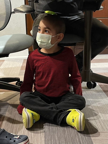 Oliver sitting under the table during a family interview at RMH-NY