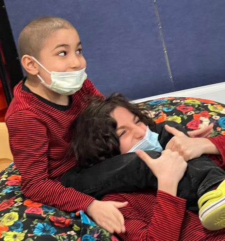 Oliver and Octavio wrestling on a bean bag in the playroom at RMH-NY