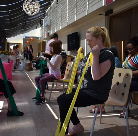 A woman sitting and exercising with a resistance band in The Wellness Center at Ronald McDonald House New York