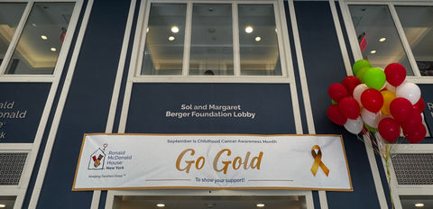 Childhood Cancer Awareness Month is September is written on the banner that hangs in the Ronald McDonald House New York's Lobby