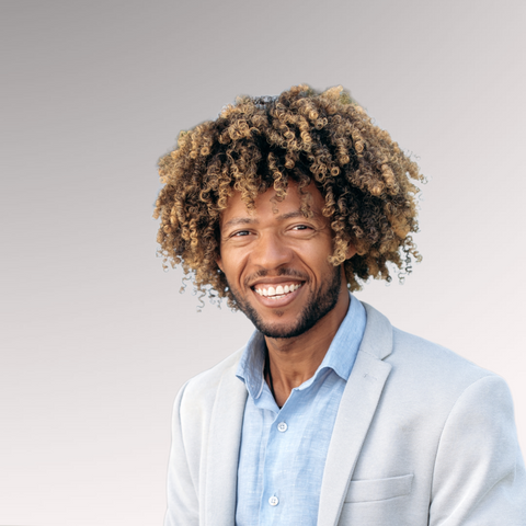 Gentleman in a sport coat smiling with longer hair demonstrating a coily hair type for men