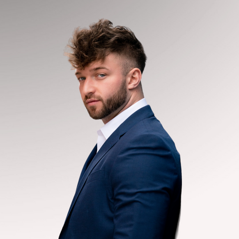 Man in a blue suit with thick hair that is medium-length demonstrating a thick fade hairstyle for men