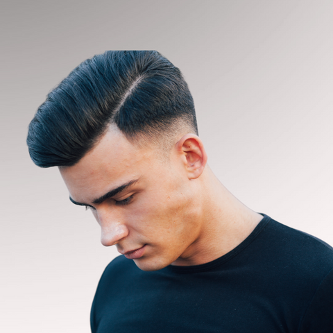 Man in a black shirt that has black, thick medium-length hair demonstrating a side brush up hairstyle for men