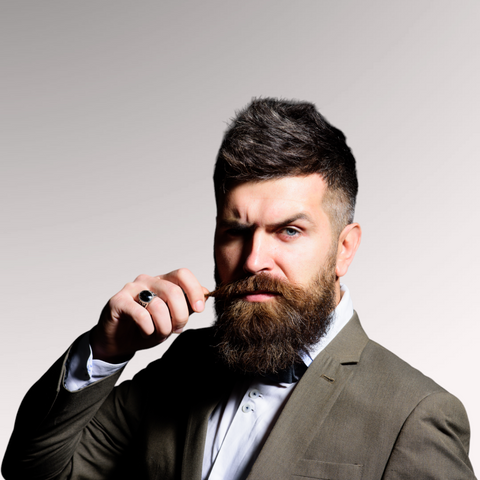 Man with a beard dressed in a suit who has medium length fine textured hair demonstrating a quiff hairstyle for men