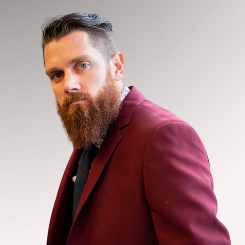 Gentleman in a red suit demonstrating a slicked back undercut hairstyle for men