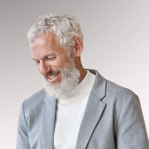 Mature gentleman with white hair and beard in a gray sport coat demonstrating an ivy league hairstyle for men who are older with thinning hair