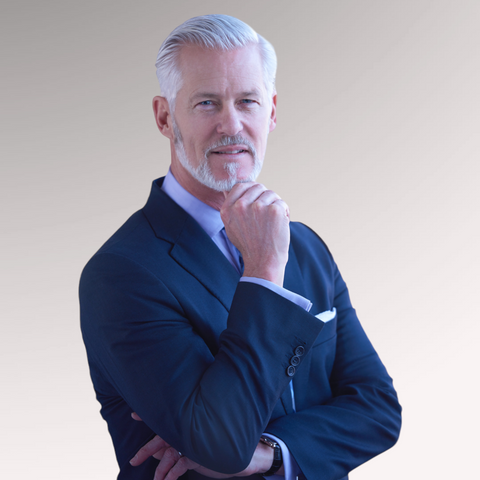 Mature man dressed in a blue suit with gray hair demonstrating a brushed back hairstyle for older men with thinning hair