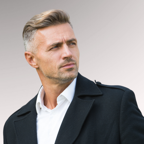 Man in a black overcoat with a sophisticated face demonstrating a textured comb-over hairstyle for men who have fine, thinning hair