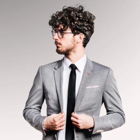 Man in a shirt, tie, and sport coat demonstrating a curly fringe hairstyle for men who have curly hair that is thinning