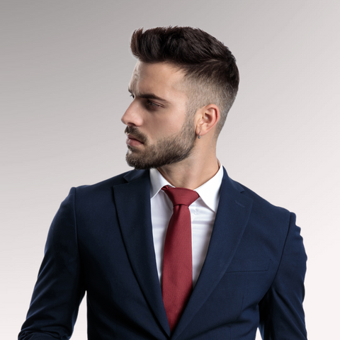 Man in a blue suit with a red tie and dark hair demonstrating a fade hairstyle for men who have thin, fine hair