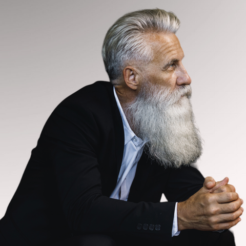 Mature man with gray hair and long styled gray beard demonstrating a long top tapered sides hairstyle for men with thin hair