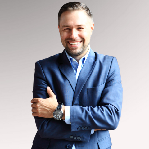 Man in a blue suit smiling demonstrating a short side part for men who are looking for a professional haircut