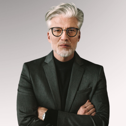 Man with gray hair and a suit demonstrating a tapered side swept with beard professional men's haircuts