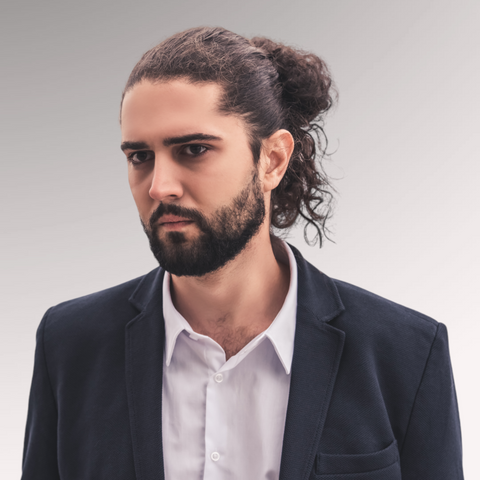 Man in a suit with long hair demonstrating a half up half down men's professional haircuts