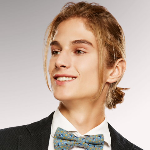 Man in a bowtie with long hair demonstrating a long ponytail professional men's haircuts